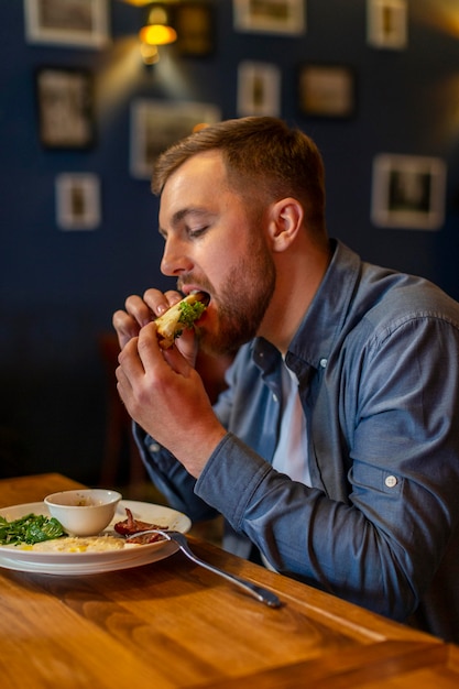 Hombre de tiro medio comiendo en la mesa