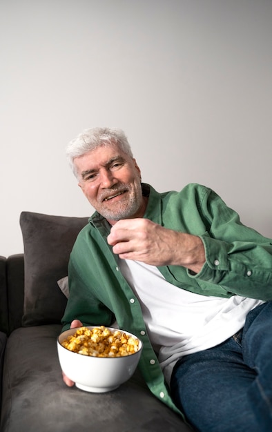 Hombre de tiro medio comiendo palomitas de maíz