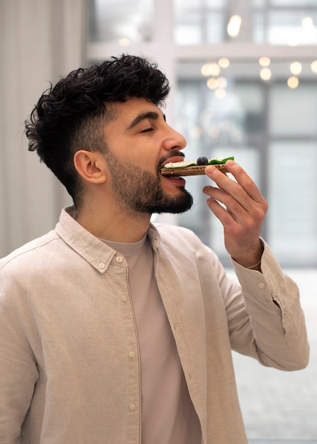 Hombre de tiro medio comiendo queso fresco