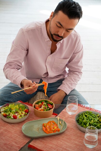 Hombre de tiro medio comiendo un tazón de salmón