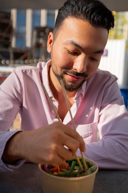 Foto gratuita hombre de tiro medio comiendo tazón de salmón