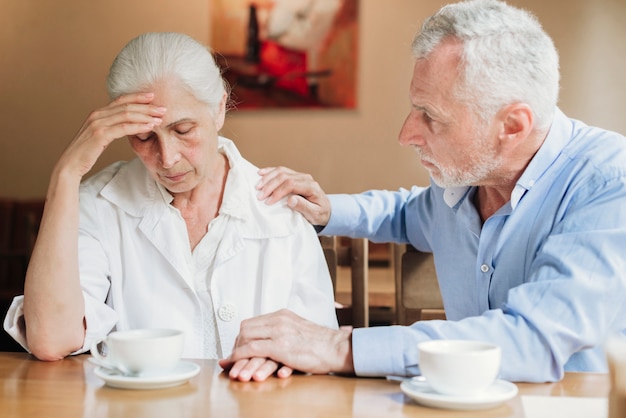 Hombre de tiro medio consolando a su esposa.