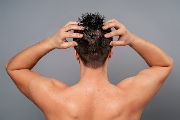 Foto gratuita hombre de tiro medio dándose un masaje en el cuero cabelludo
