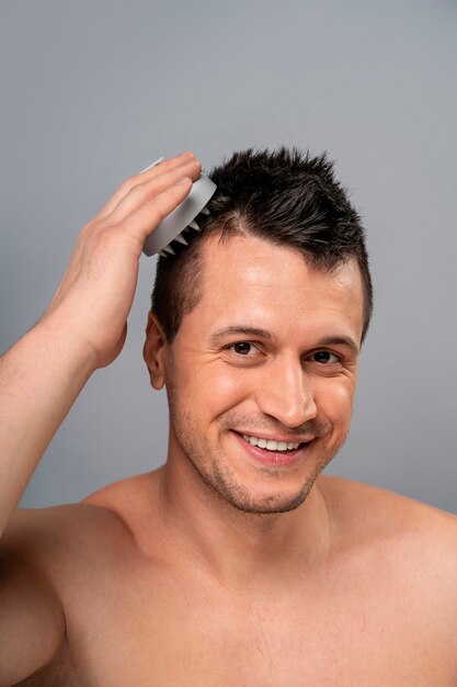 Hombre de tiro medio dándose un masaje en el cuero cabelludo