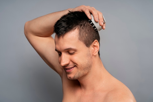 Foto gratuita hombre de tiro medio dándose un masaje en el cuero cabelludo