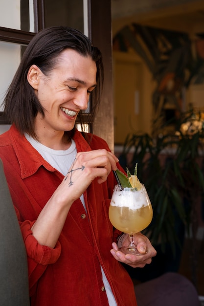 Hombre de tiro medio con delicioso cóctel.