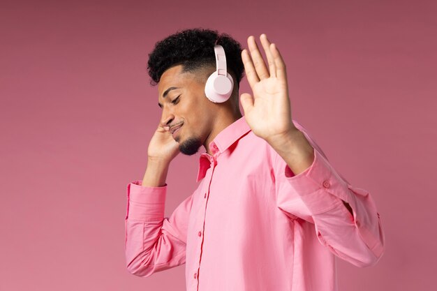 Hombre de tiro medio divirtiéndose con auriculares