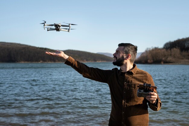 Hombre de tiro medio con drone al aire libre