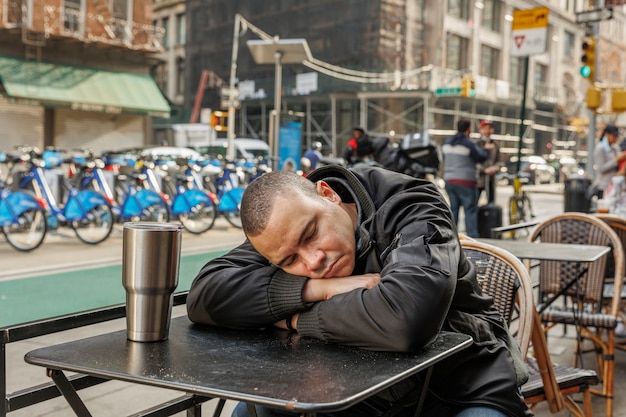 Hombre de tiro medio durmiendo con la cabeza sobre la mesa