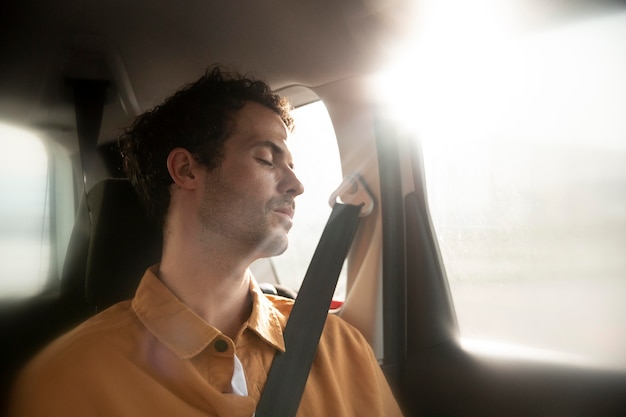 Hombre de tiro medio durmiendo en el coche