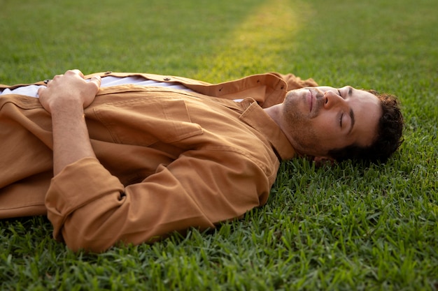 Foto gratuita hombre de tiro medio durmiendo sobre el césped