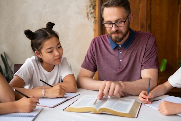 Foto gratuita hombre de tiro medio enseñando la biblia