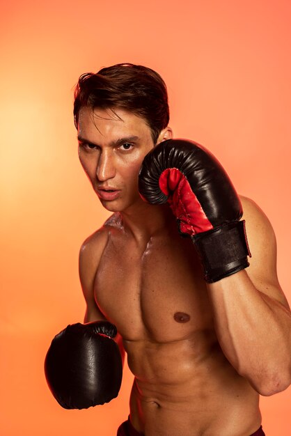 Hombre de tiro medio entrenando con guantes de boxeo