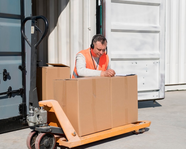 Hombre de tiro medio escribiendo en caja