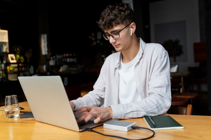 Foto gratuito hombre de tiro medio escribiendo en la computadora portátil