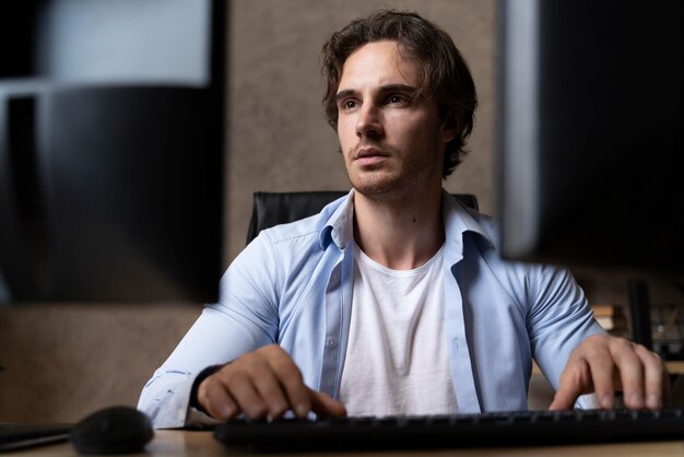 Hombre de tiro medio escribiendo en el teclado