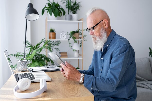 Hombre de tiro medio estudiando con dispositivos