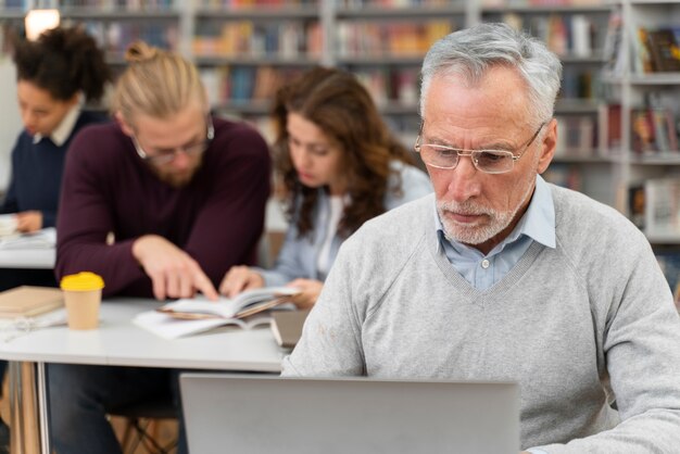 Hombre de tiro medio estudiando con portátil