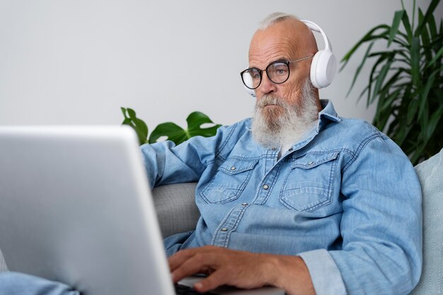 Hombre de tiro medio estudiando en el sofá