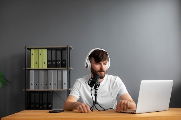 Hombre de tiro medio grabando podcast con auriculares