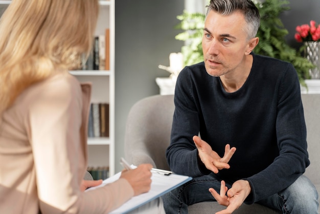 Hombre de tiro medio hablando con el terapeuta