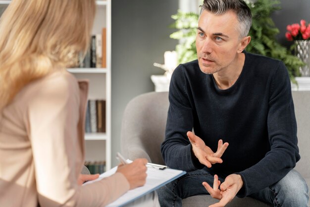 Hombre de tiro medio hablando con el terapeuta