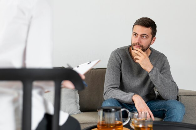 Hombre de tiro medio hablando con el terapeuta