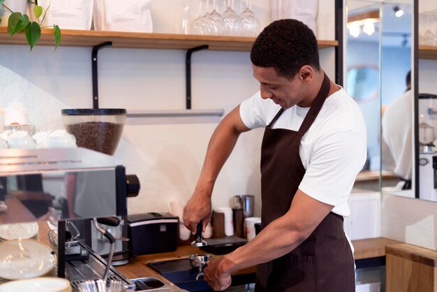 Hombre de tiro medio haciendo café