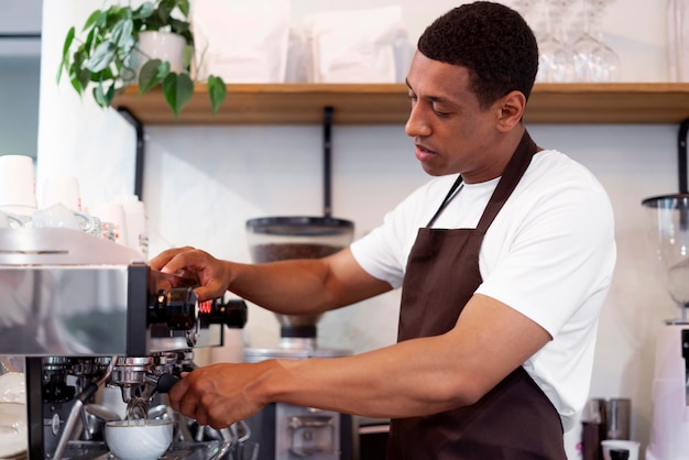 Hombre de tiro medio haciendo café