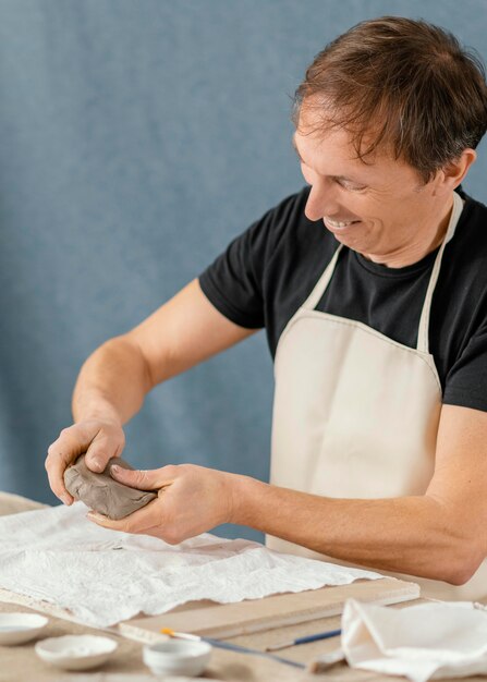 Hombre de tiro medio haciendo cerámica en casa