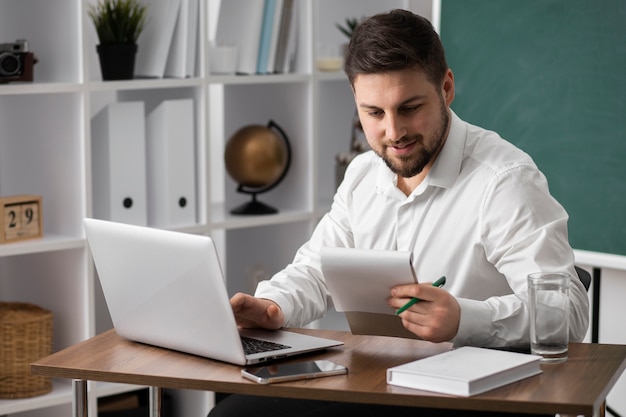 Foto gratuita hombre de tiro medio haciendo lista con laptop