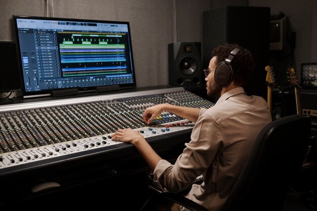 Hombre de tiro medio haciendo música con la computadora