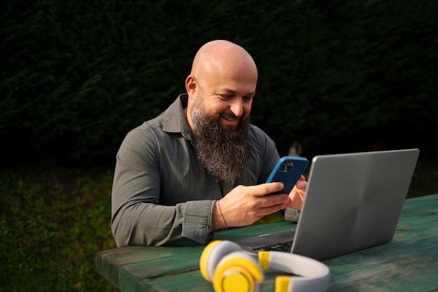 Foto gratuita hombre de tiro medio con laptop al aire libre