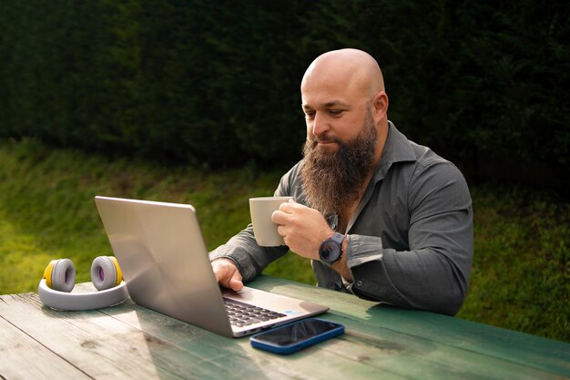 Hombre de tiro medio con laptop al aire libre