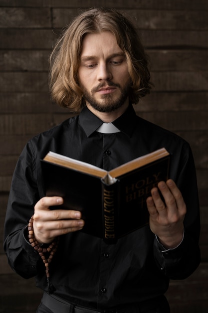 Hombre de tiro medio leyendo la biblia