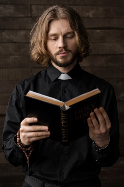 Hombre de tiro medio leyendo la biblia