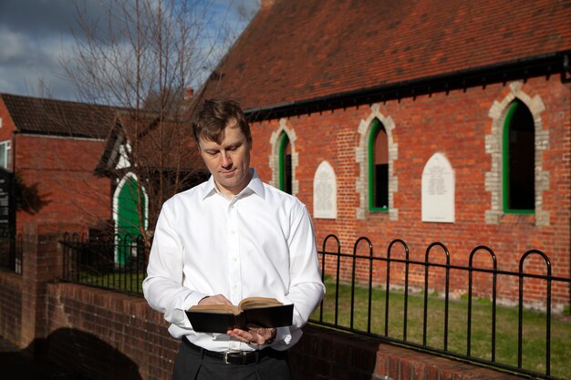 Hombre de tiro medio leyendo la biblia