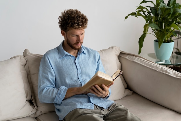 Hombre de tiro medio leyendo en casa