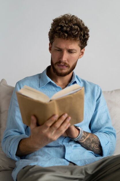 Hombre de tiro medio leyendo en casa