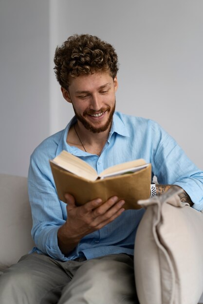 Hombre de tiro medio leyendo en casa