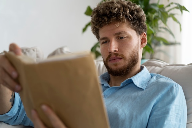 Foto gratuita hombre de tiro medio leyendo en casa