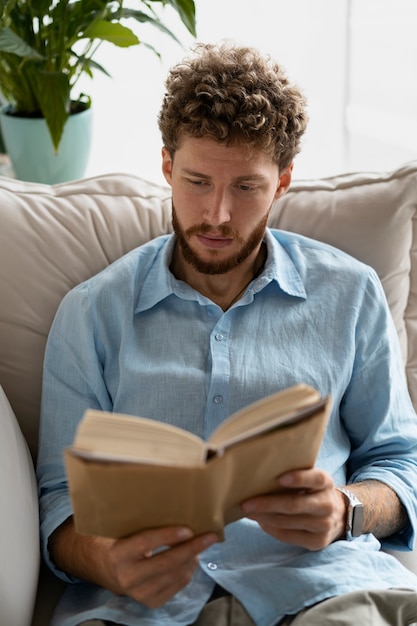 Hombre de tiro medio leyendo en casa