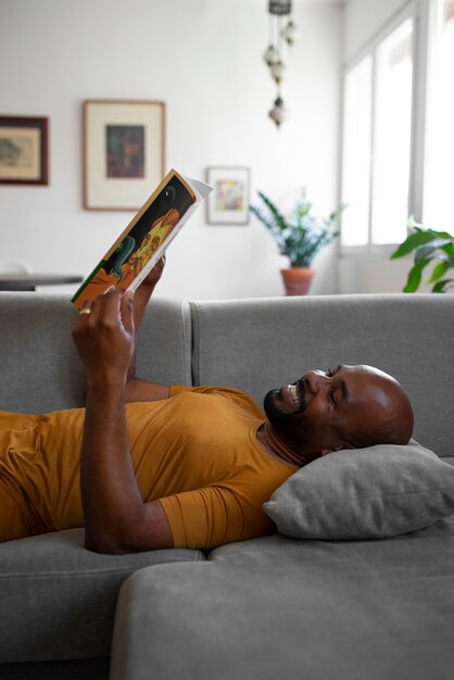 Hombre de tiro medio leyendo cómics en casa