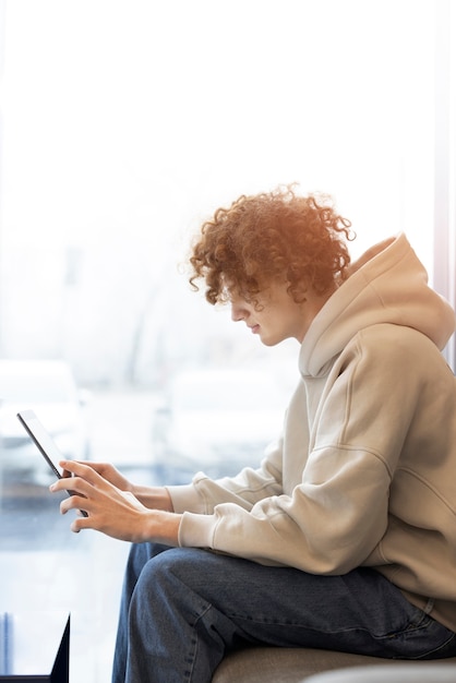 Foto gratuita hombre de tiro medio leyendo una revista digital.