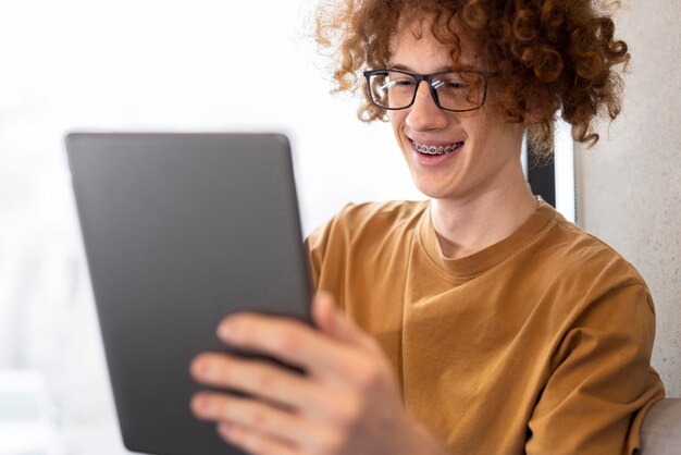 Hombre de tiro medio leyendo una revista digital.