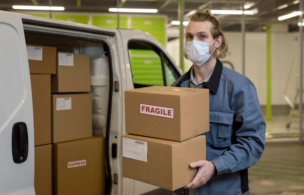 Hombre de tiro medio llevando cajas