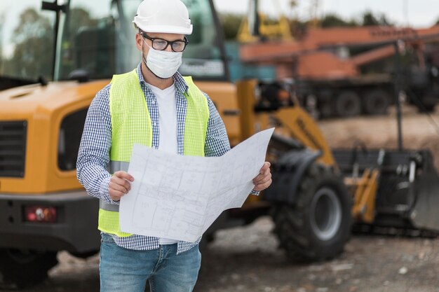 Hombre de tiro medio con máscara y proyecto