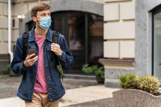 Foto gratuita hombre de tiro medio con mascarilla mirando lejos