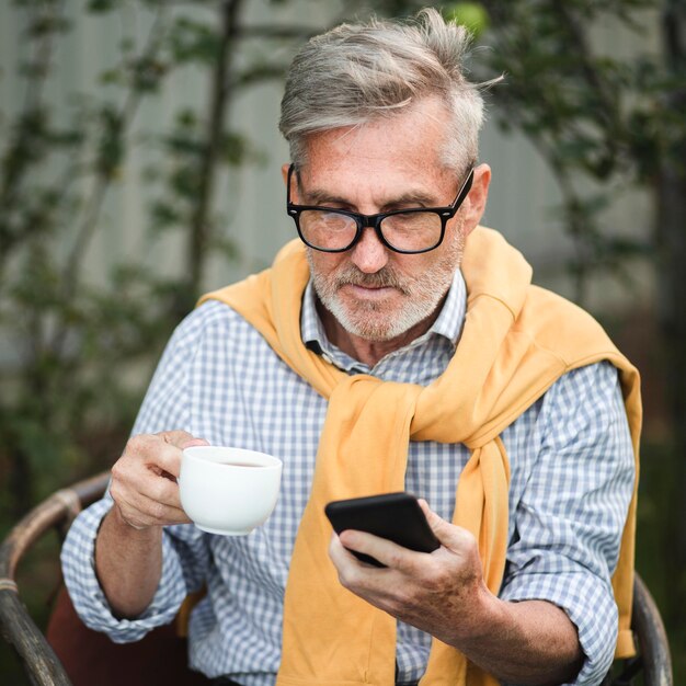 Hombre de tiro medio mirando smartphone