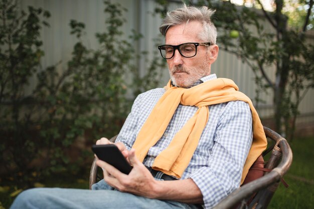 Hombre de tiro medio mirando el teléfono